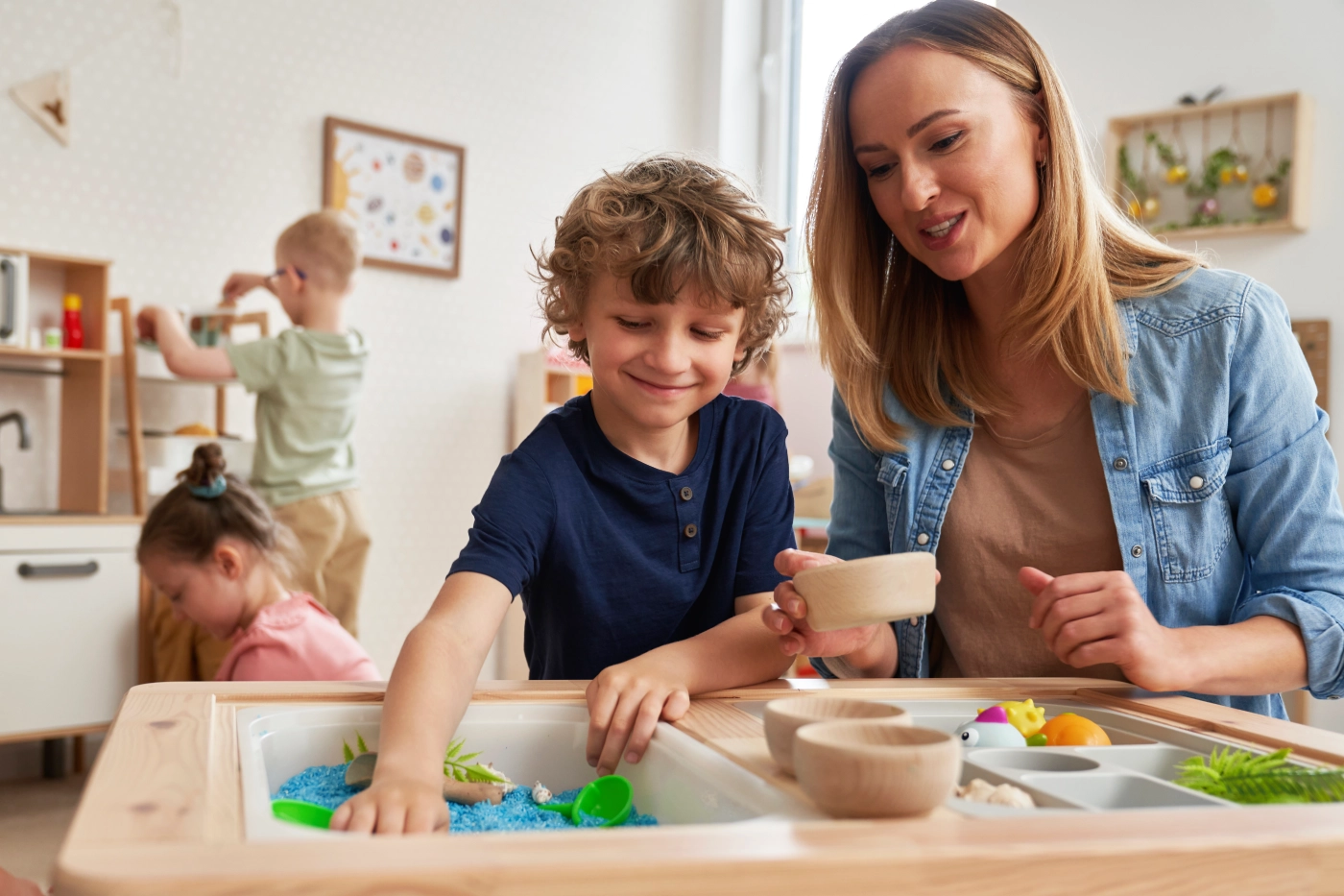 GettyImages-2151872604 Child and adult playing with sensory table.