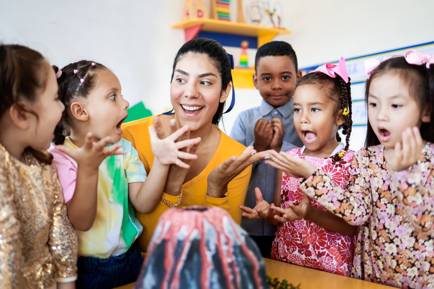 GettyImages-2158503357 Teacher and children excited about volcano experiment.