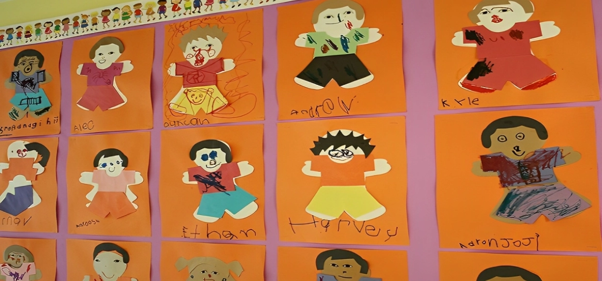 Children's artwork displayed on a colorful wall.