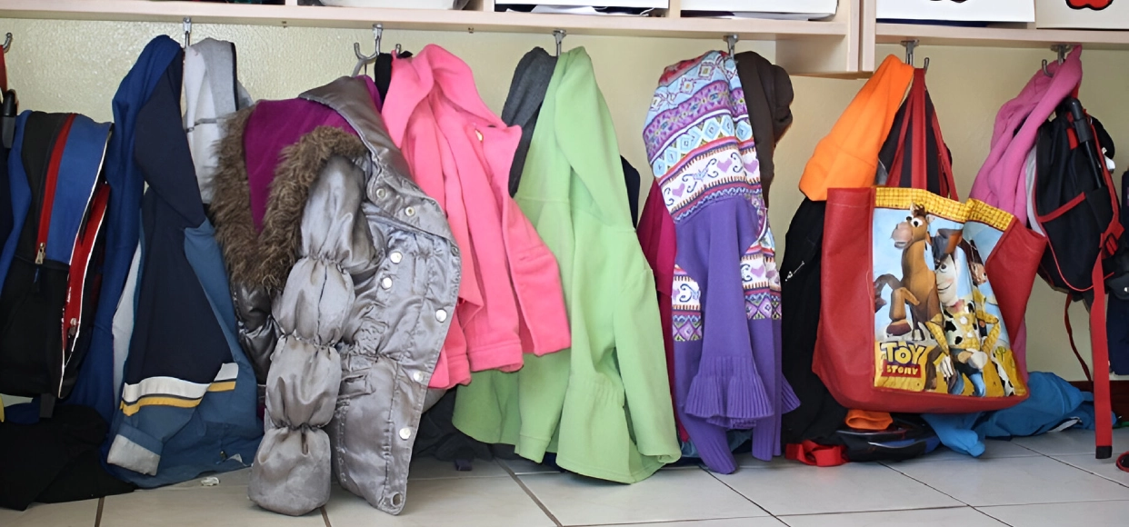 Coats and bags hanging in a row.