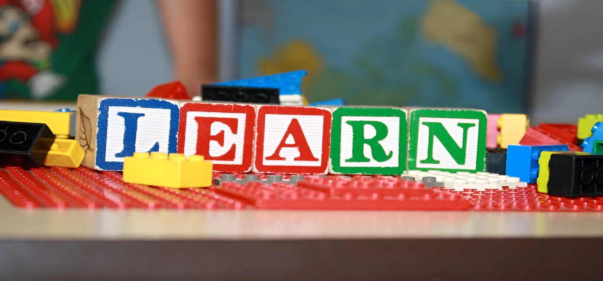 Toy blocks spelling "LEARN" on a table.
